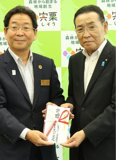 福元市長と志水理事長が目録を二人でカメラに向けて手にもっている記念写真