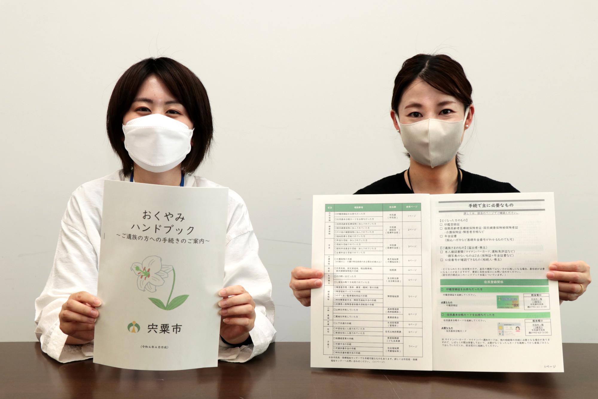 市が作ったおくやみハンドブックを市役所で紹介する職員