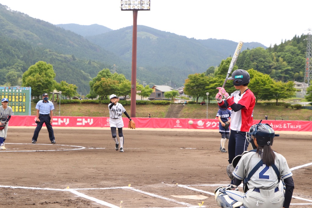 波賀メイプルスタジアムでJDリーグの試合前のファーストピッチングをする宍粟市内中学校のソフトボール部員らの写真