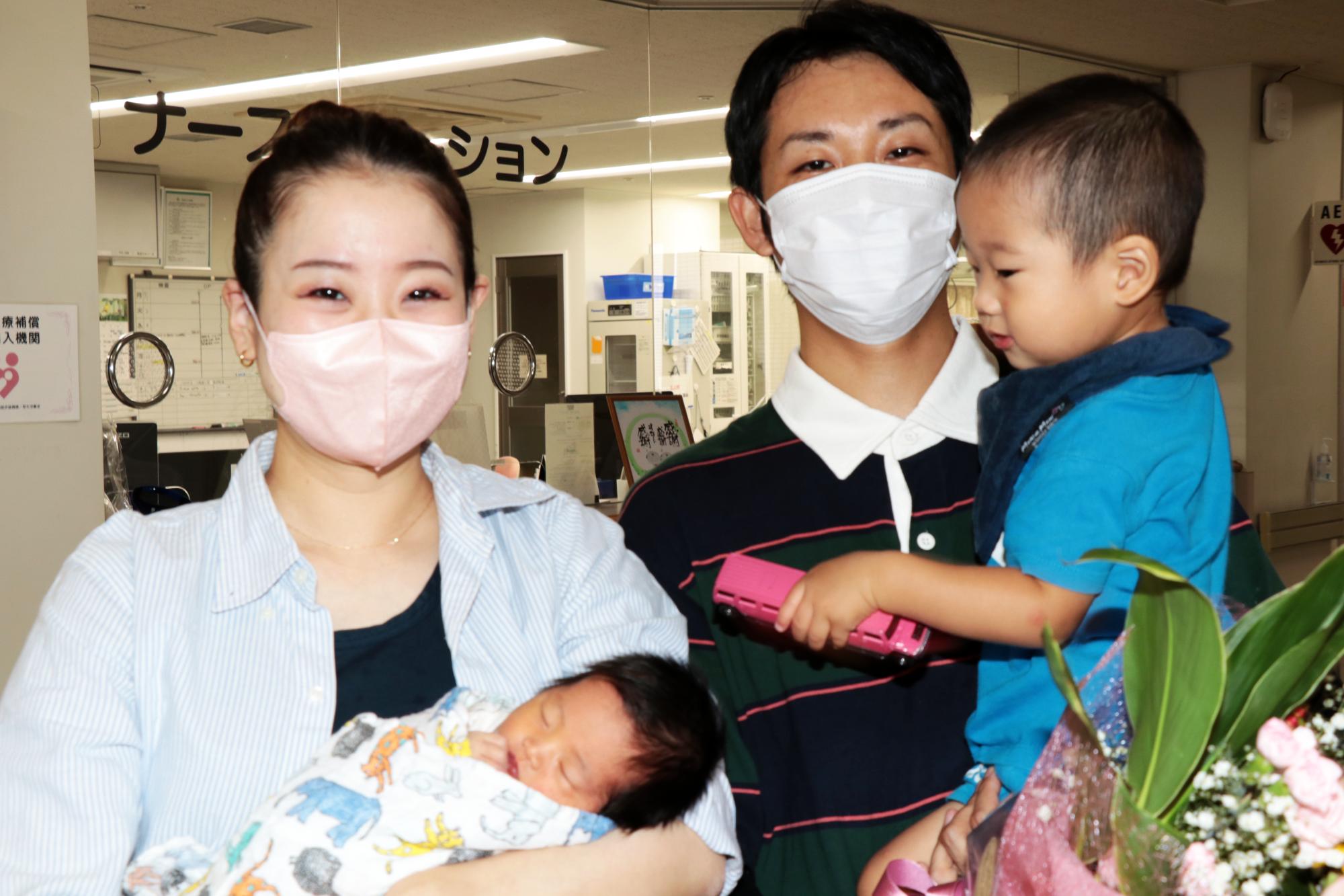 宍粟総合病院の8千人目の赤ちゃん 石原桃亜さんを抱く母の沙耶さんと父の玄貴(はるき)さんが並んでいる写真