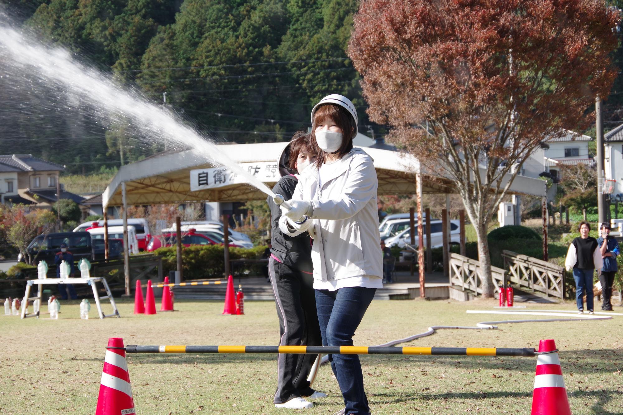 参加者の二人がホースを持って放水している写真