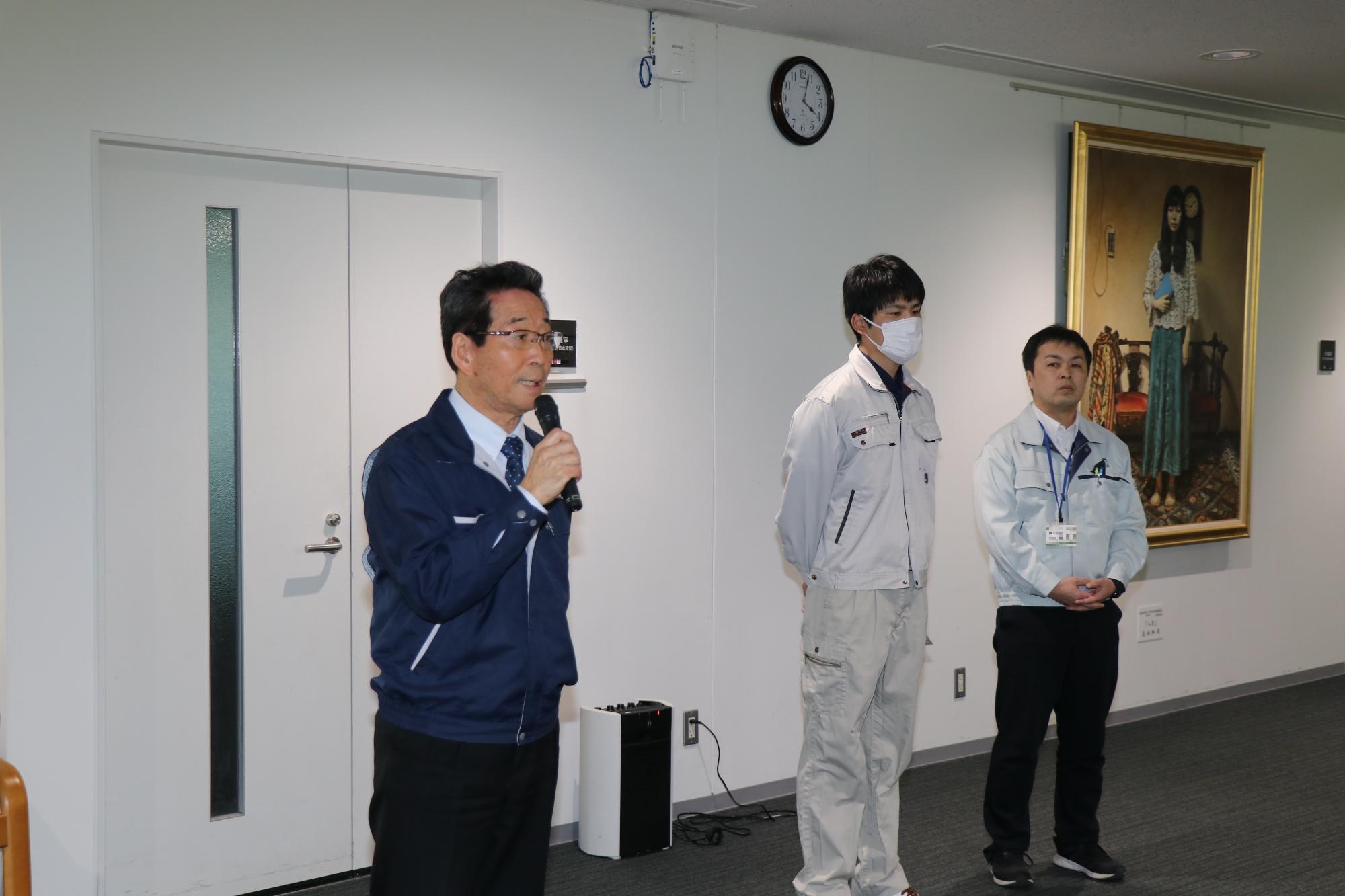 福元市長が市役所3階のロビーで派遣される職員二人に向けて激励している写真