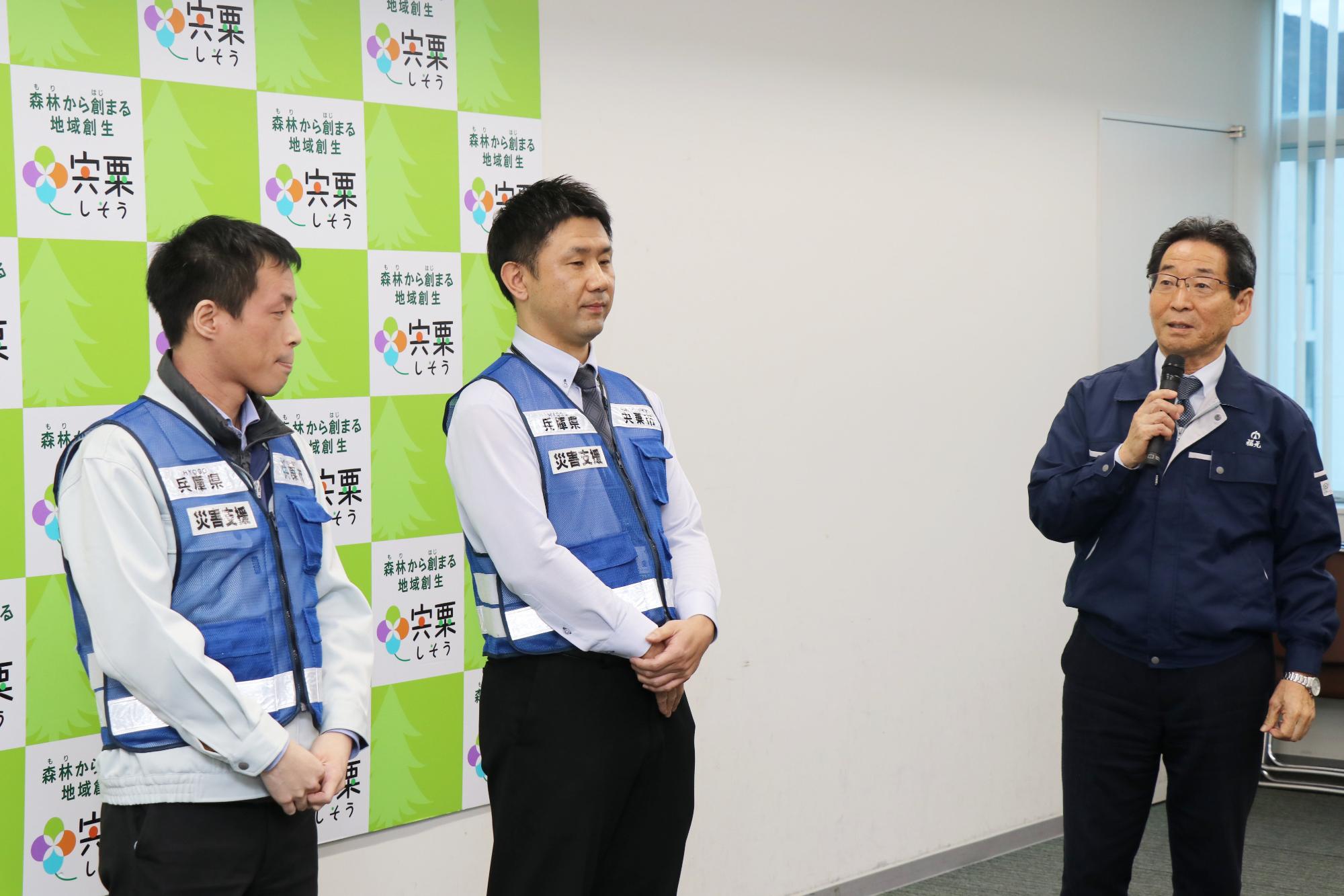 福元市長が市役所3階の会議室で派遣される職員二人に向けて激励している写真