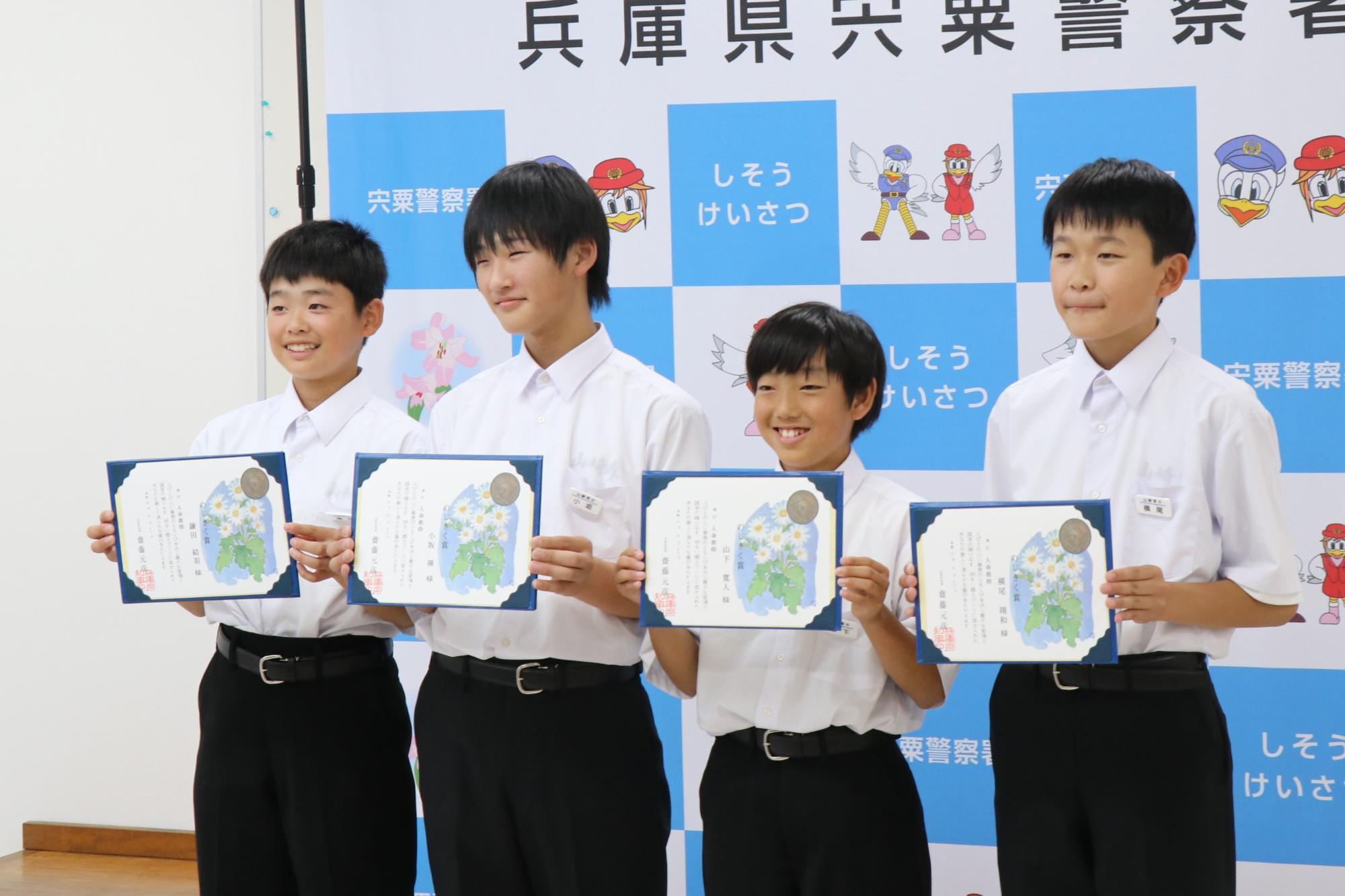 のじぎく賞が贈られた山崎東中学校1年生4人と賞状を手に並んで立っている写真