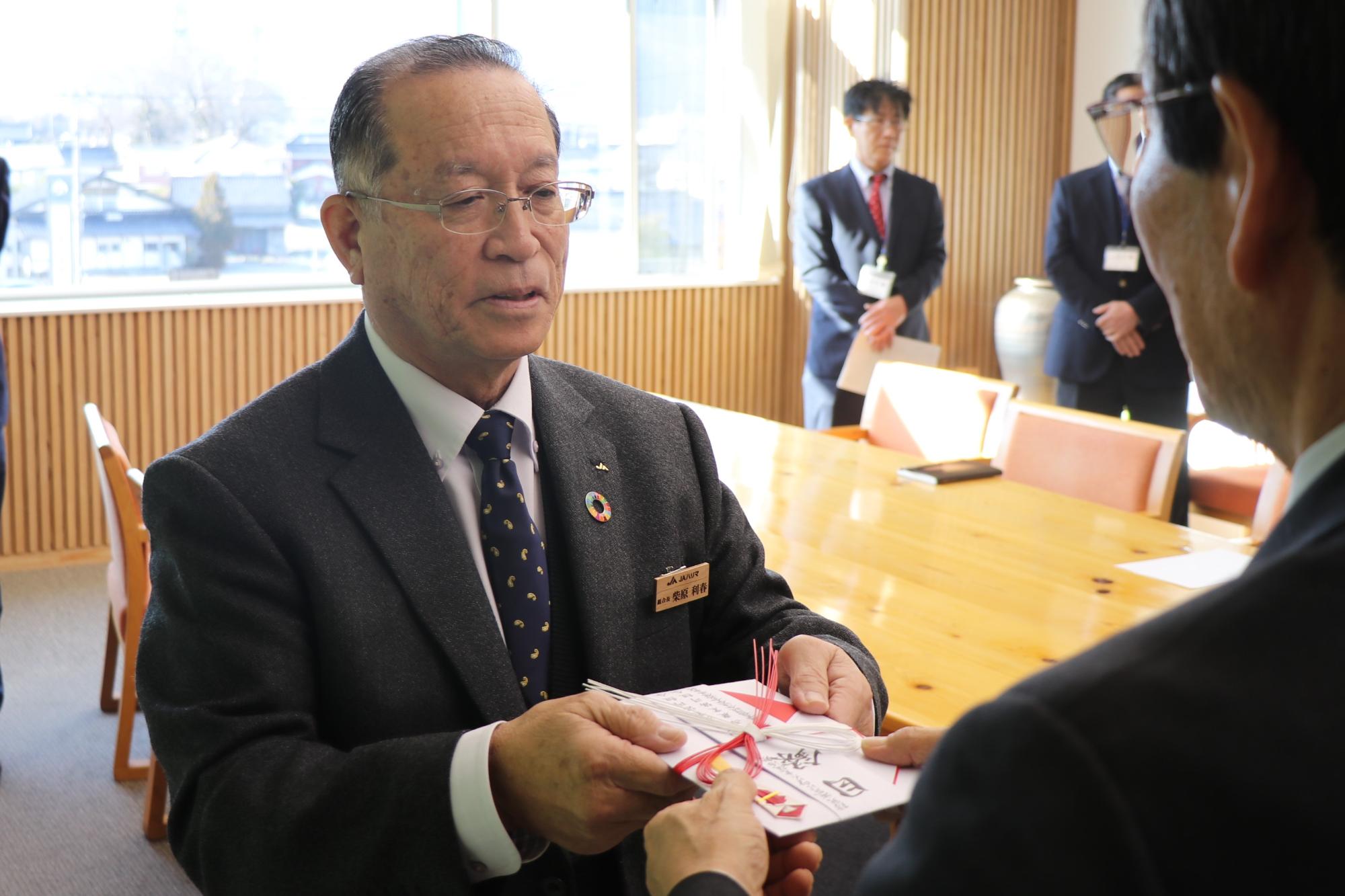 市長に目録を手渡す柴原組合長