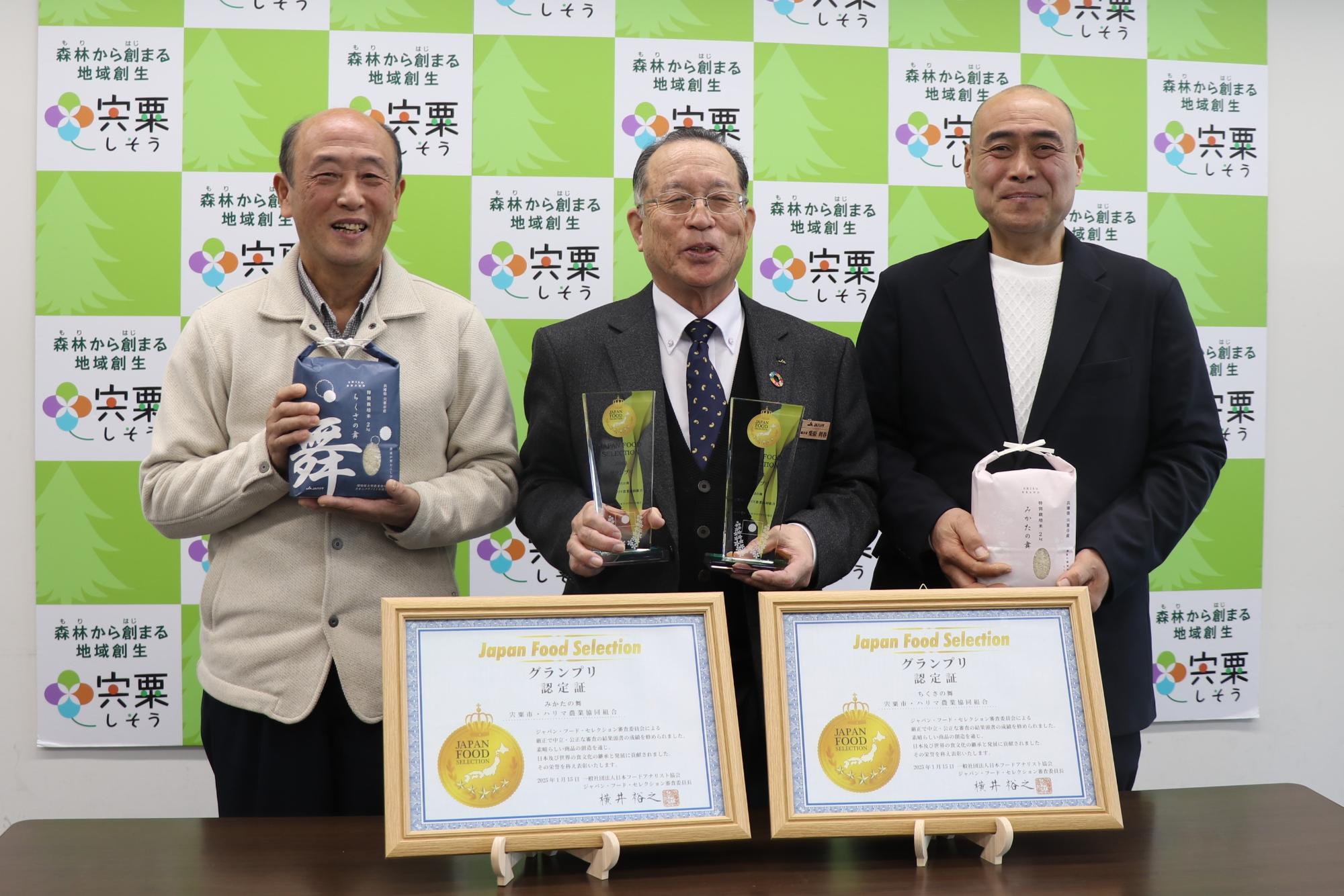 受賞したお米を手に持った杉本さん(右)と段林さん(右)、受賞トロフィーを手に持った柴原組合長(中)が並んでいる写真