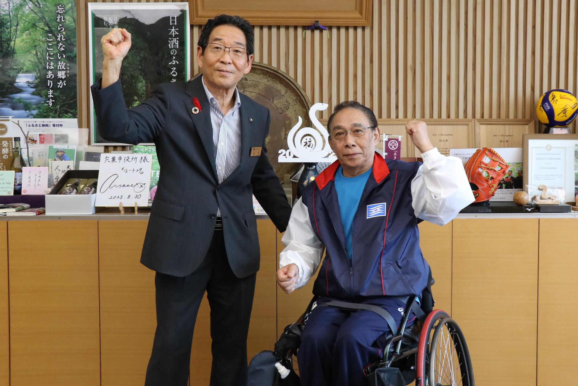 市長と国スポへの出場を決めた福井さんがガッツポーズをしている様子