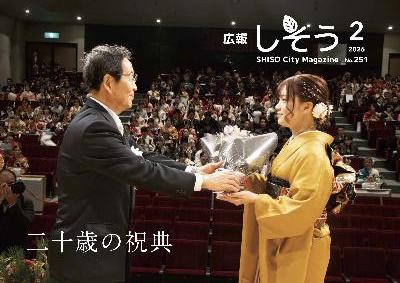 広報2月号:二十歳の祝典で市長から花束を受け取っている二十歳代表者の写真
