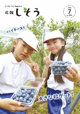 広報7月号:山崎西小学校の2年生の児童がブルーベリーを手にピースする様子