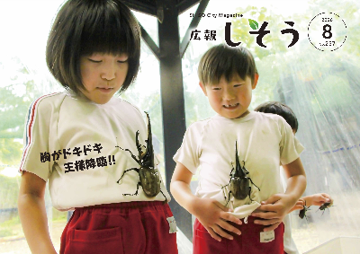 広報8月号:波賀幼稚園の園児2人がヘラクレスオオカブトをお腹にとまらせて楽しんでいる様子