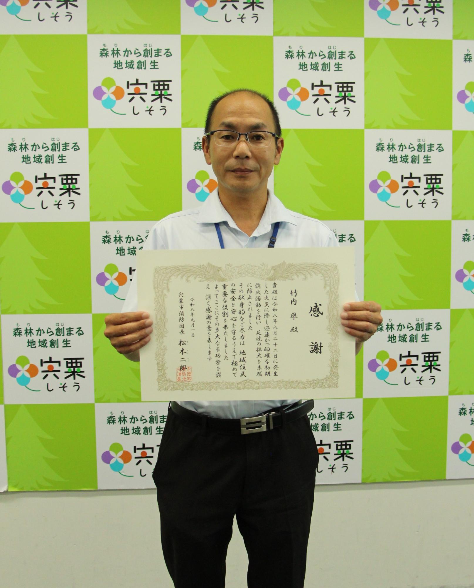 感謝状を抱える竹内さん