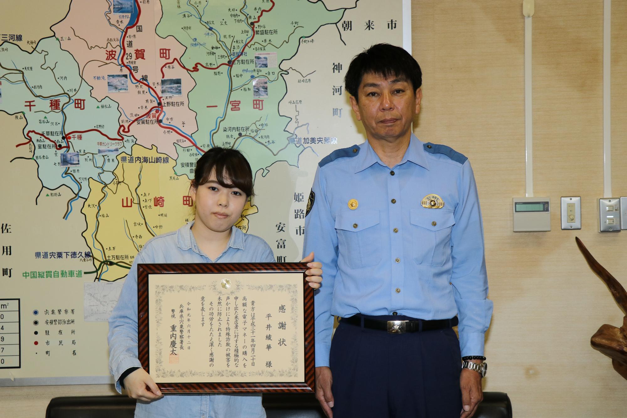 額縁に入った感謝状を持つ平井さんと宍粟市警察長の写真