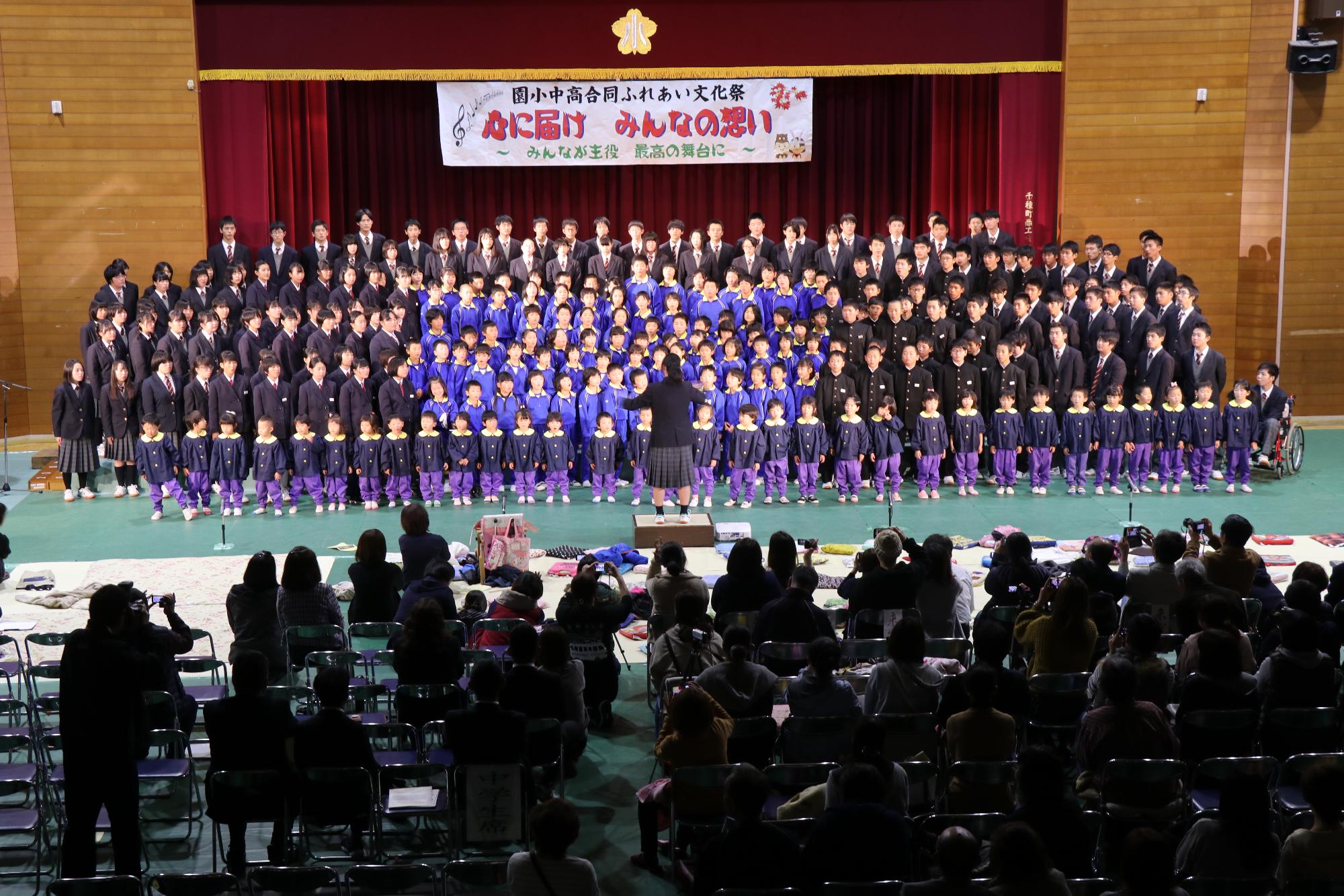 園児から高校生まで262人が合唱をする写真