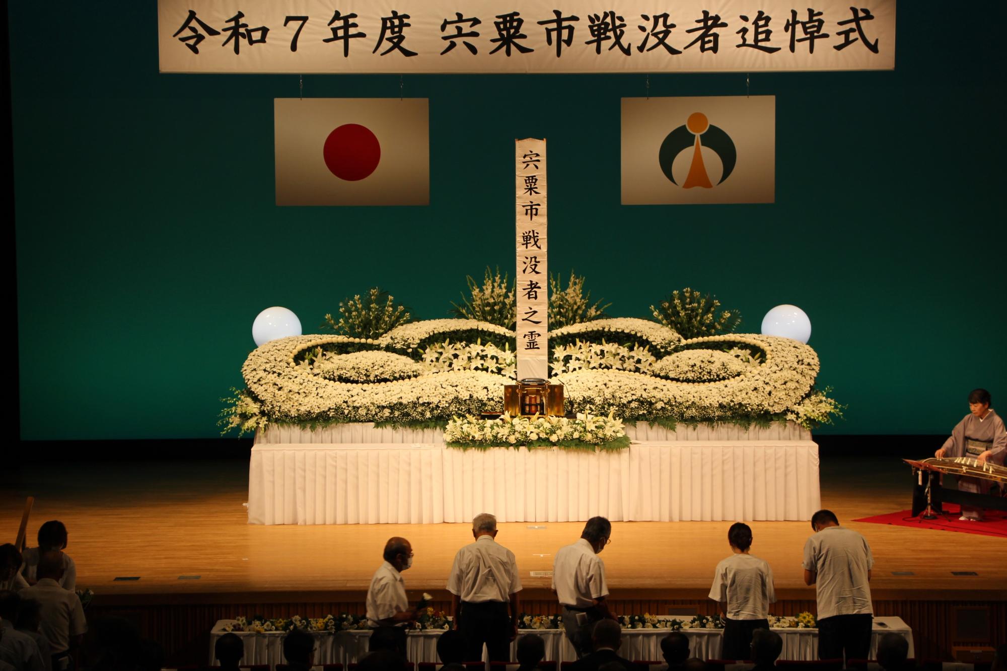 山崎文化会館で開かれた戦没者追悼式で献花を捧げる参列者ら