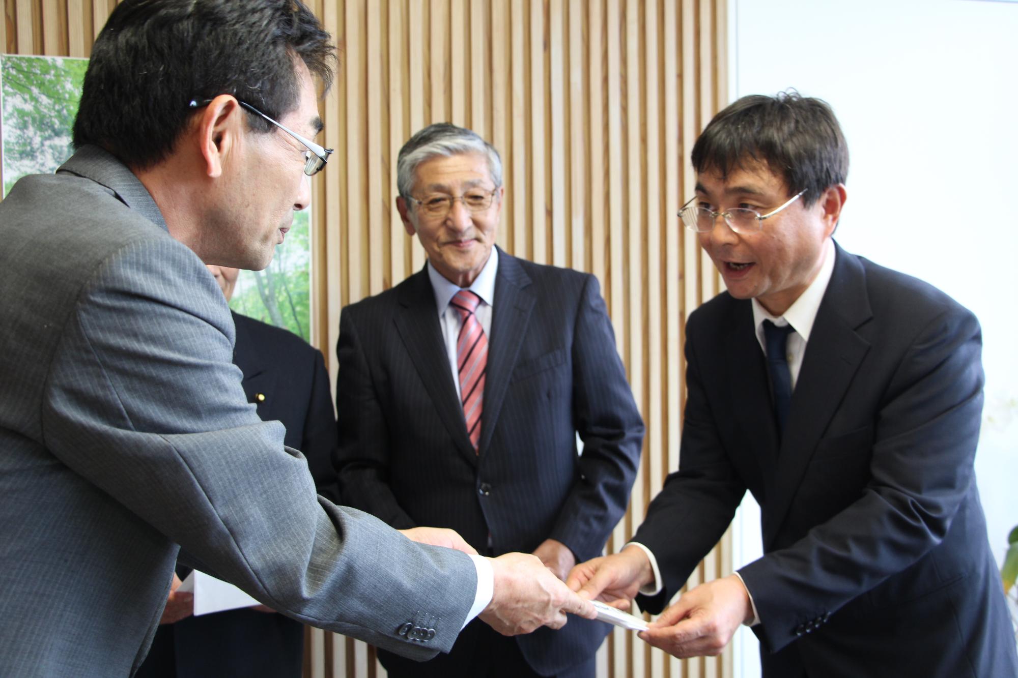 副市長室で副市長が匝瑳市観光室の小泉室長に見舞金を手渡している写真