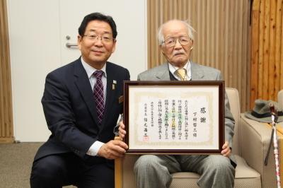 下村氏に感謝状を贈呈し記念撮影をする市長の写真