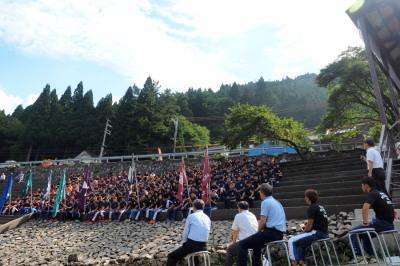 湖沿いの石段に座る関西学生カヌー選手権大会に出場する200人を超す学生たちの写真