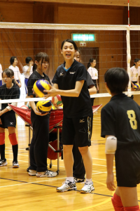 迫田さおりさんがネットの前でボールを持ち大声で指導を行う様子の写真