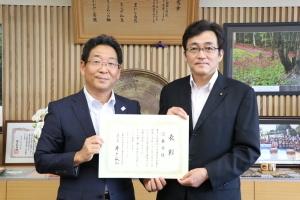兵庫県交通安全対策委員会会長と市長が表彰状を手にしている記念写真