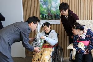 はりま自立の家の車椅子に乗った代表者よりリースの寄贈をうける市長とそれを見る施設関係者らの写真