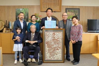 寄贈された伊勢柿渋型紙彫刻と和田正弘氏と市長の写真