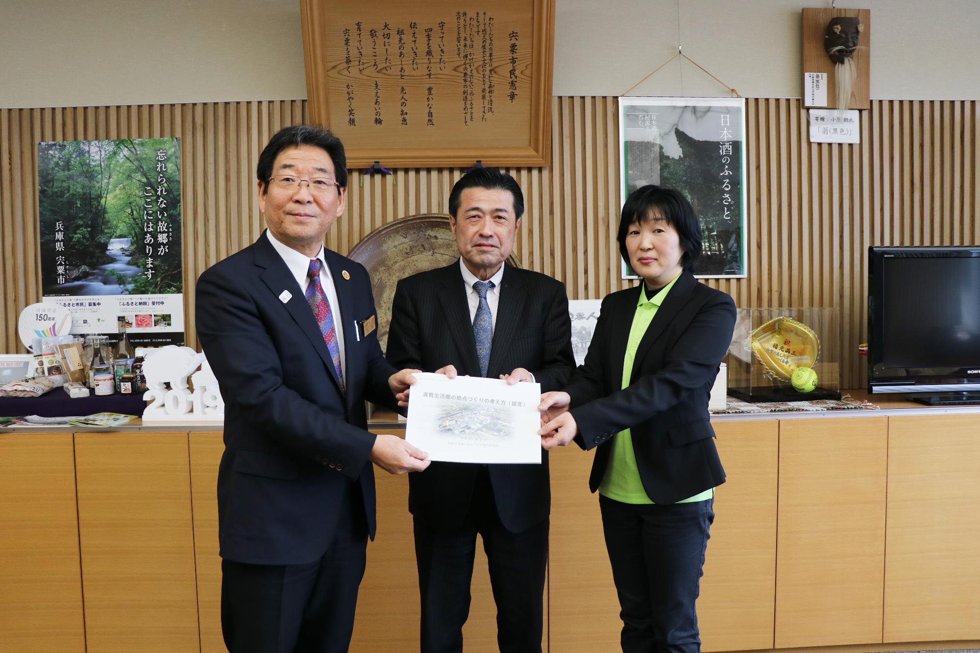 「波賀生活県の拠点づくりの考え方」の提言書を市長と検討委員会の2人が手に持っている記念写真
