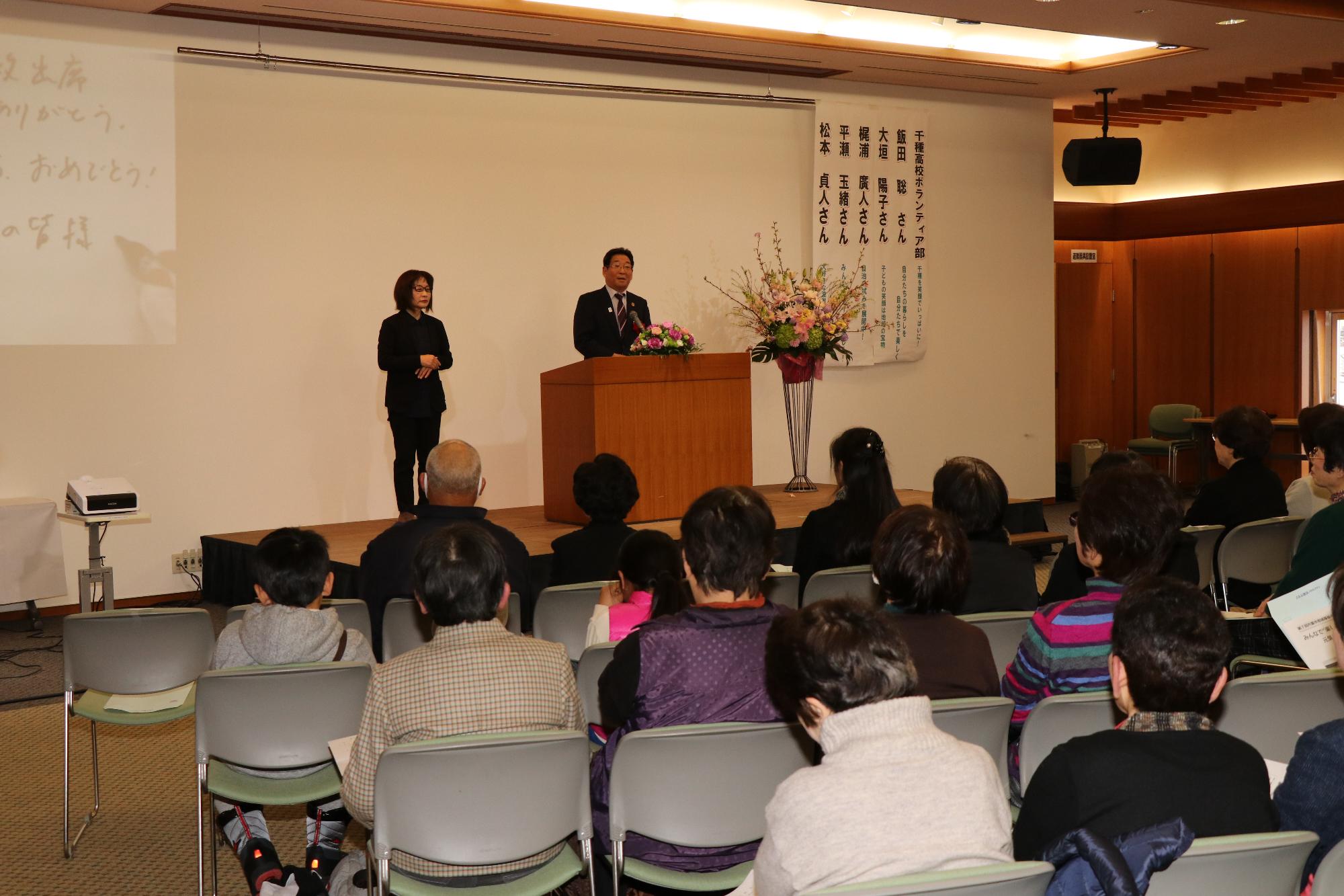 宍粟市地域福祉のつどいに出席した人たちが壇上の市長のスピーチを聞いている写真