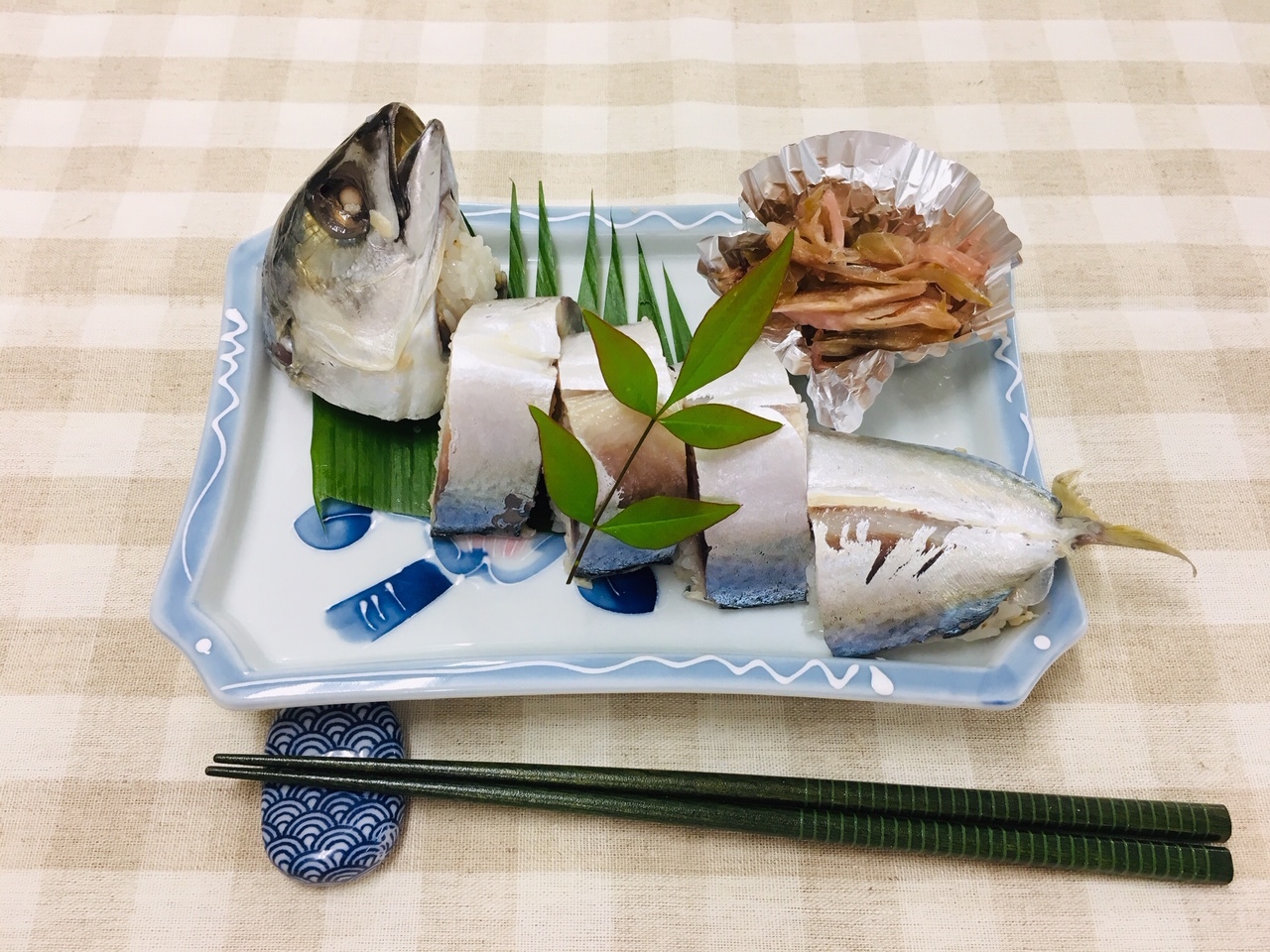 尾頭付きの鯖寿司が盛り付けられている写真