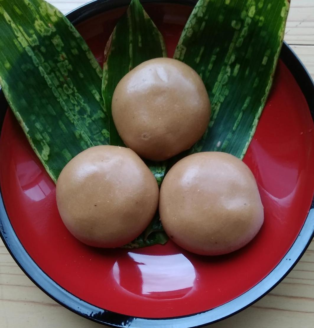 朱塗りの器の中に敷かれた緑のバランの上にとち餅が三角に並んでいる写真