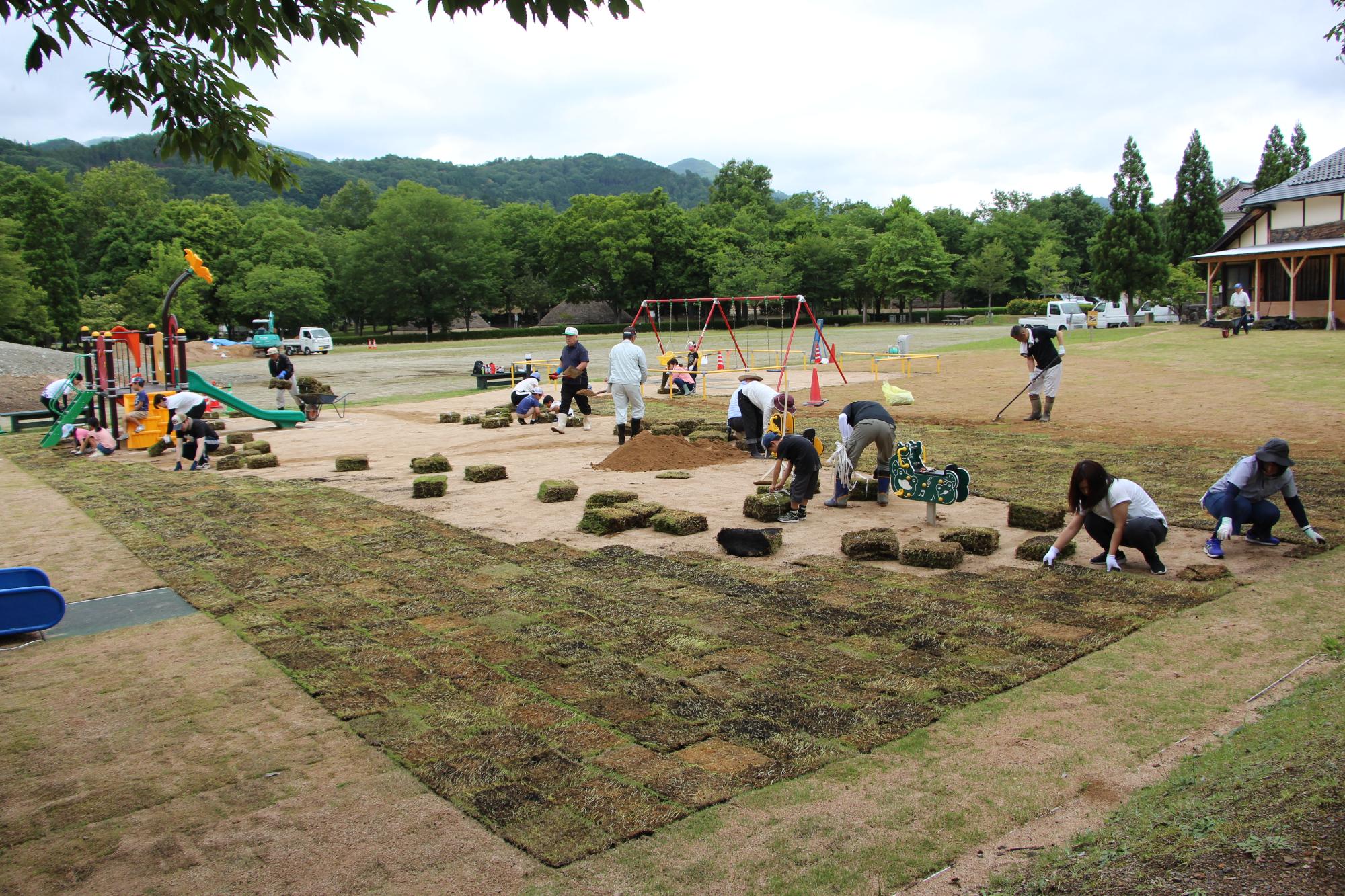 委員会と地元住民らが家原遺跡公園に芝生を植栽している写真