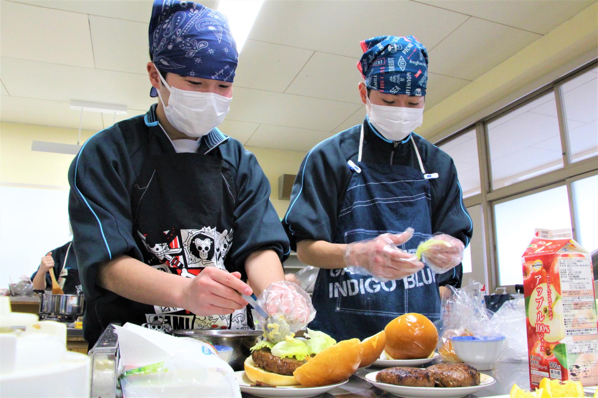 鹿のミンチ肉で作ったハンバーガーに、奈良漬けで味付けしたタルタルソースを挟む生徒の写真