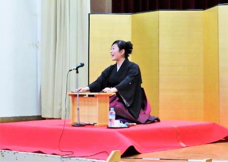 旭堂小南陵さんが金屏風の前で赤い毛氈の上に座り話をしている写真