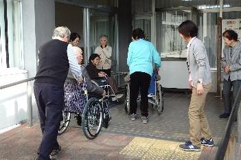 車椅子に乗る体験をしている参加者らの写真