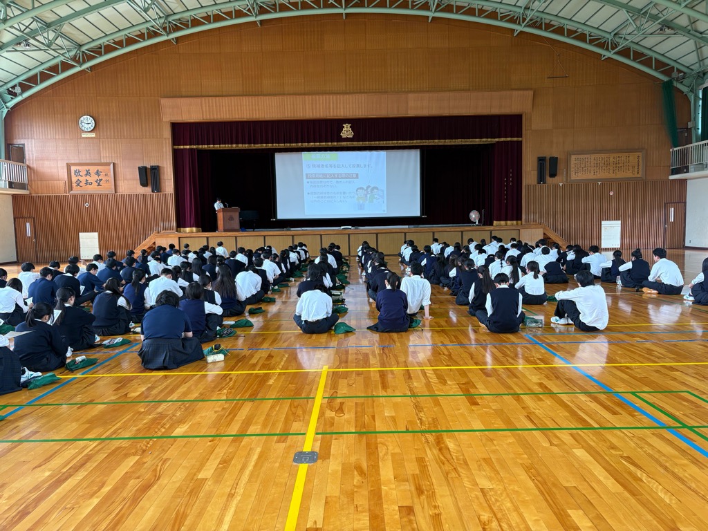 山崎高校の生徒が、体育館で選挙の出前授業を受けている写真