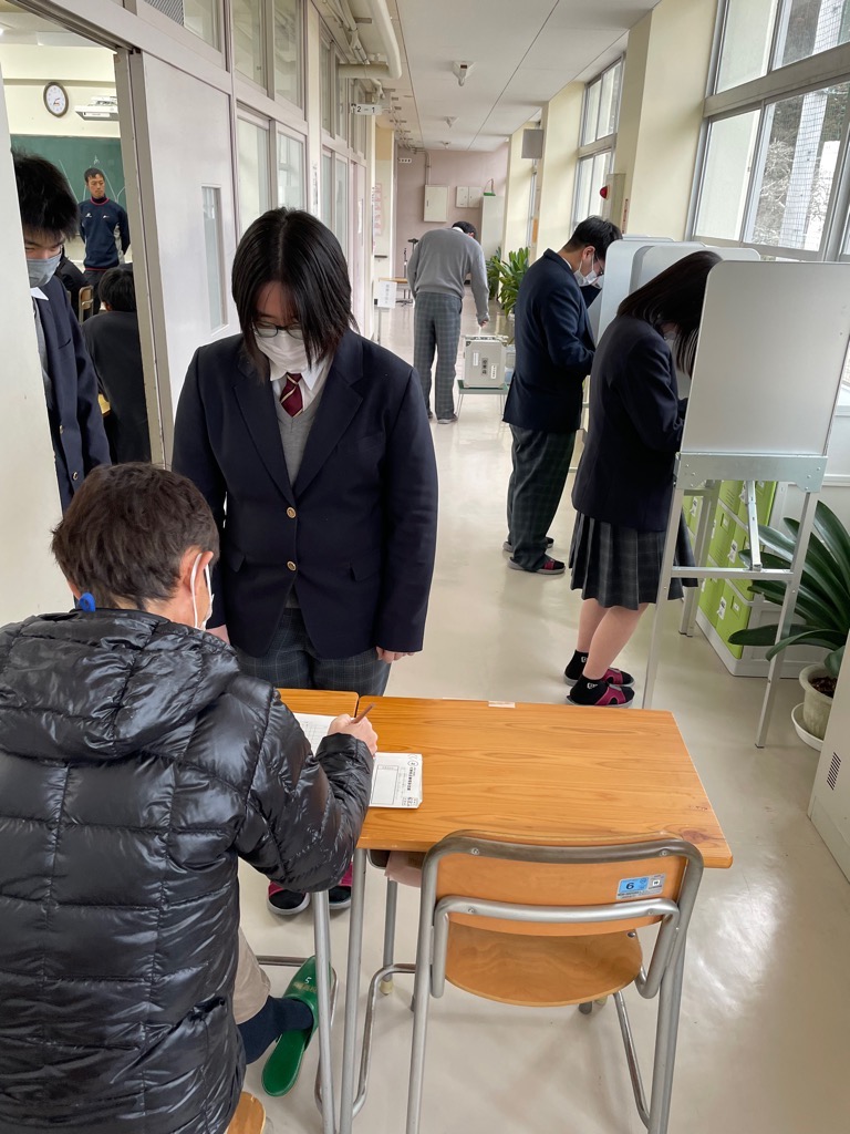 投票所を再現し擬似投票を体験する生徒たちの写真