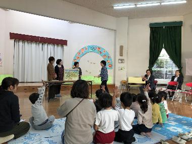 人権委員が人権啓発活動として紙芝居を子どもたちに読み聞かせている写真