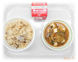 さといもを使った炊き込みご飯と味噌汁と牛乳がトレイに並んだ食育の日の献立の写真