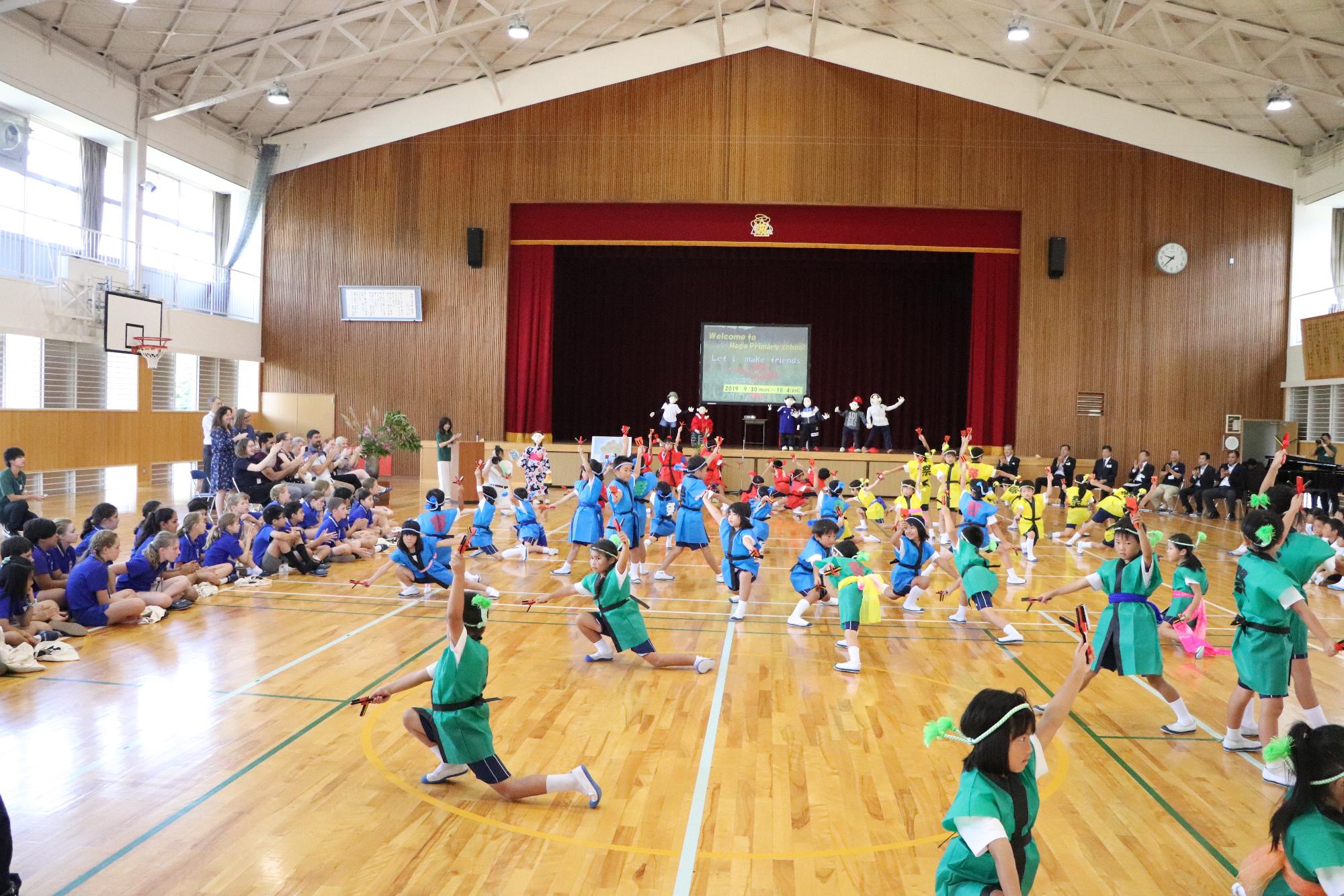 波賀小学校の低学年がダンスでアイアンサイド小学校生を歓迎している写真