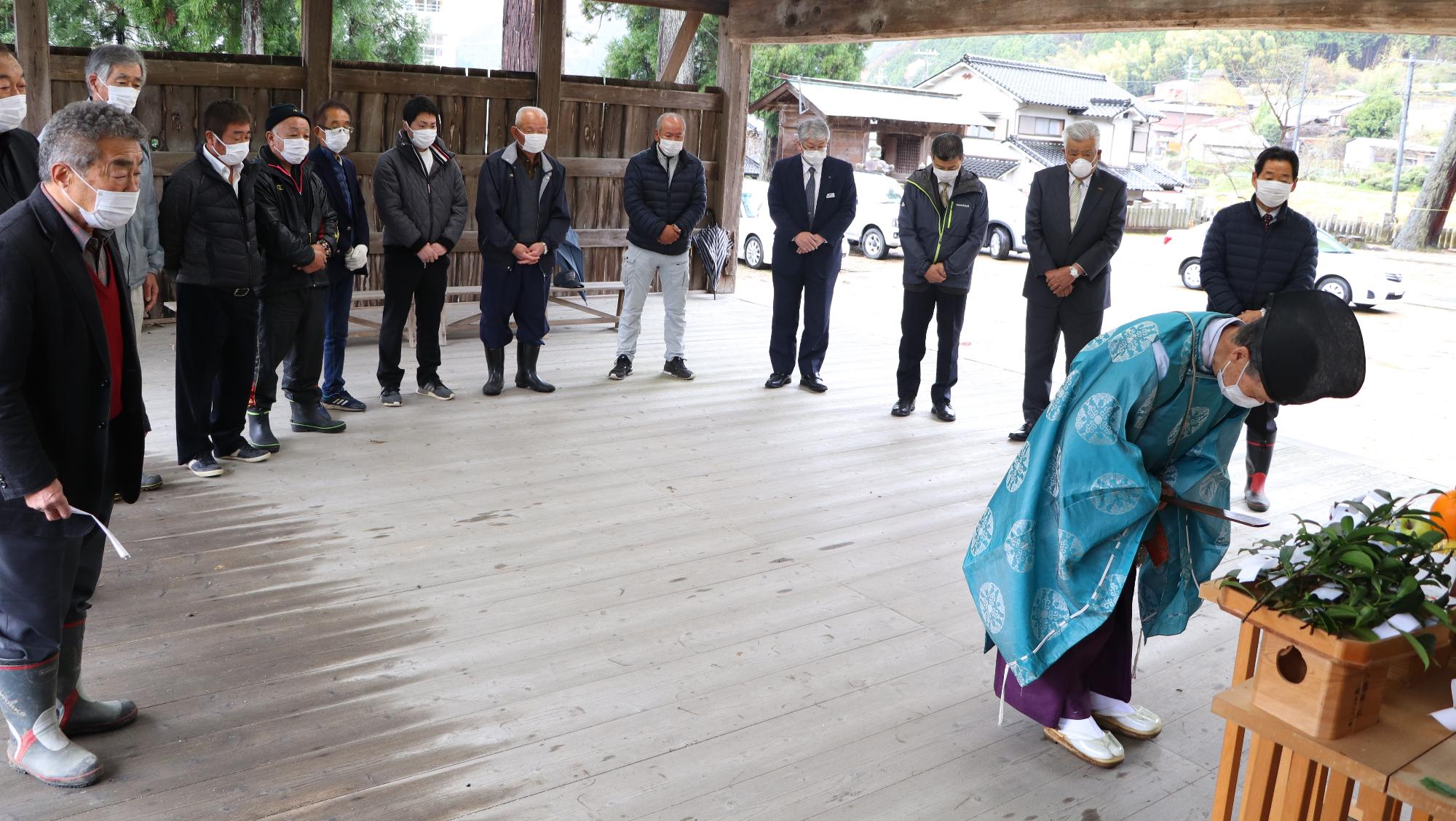 関係者らがぐるりと神主を取り囲み、神主が木霊に祈りを捧げている写真