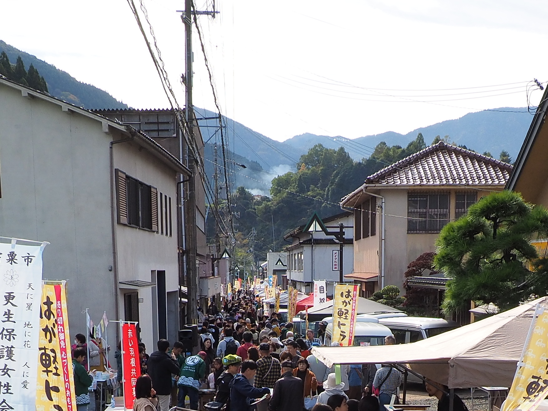 軽トラとのぼりが並ぶ上野商店街の通りが買い物客で埋め尽くされている写真