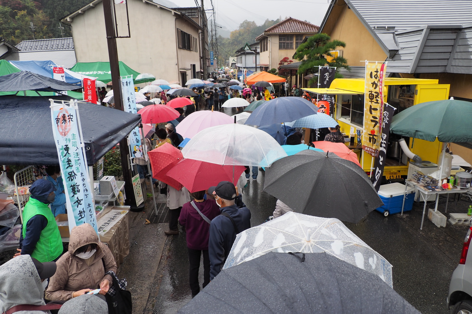 雨の中で傘をさして順番を待つ来場者