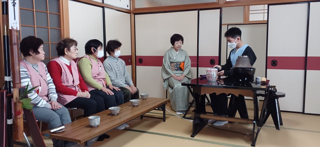 来場者を前に生徒がお茶を点てている写真