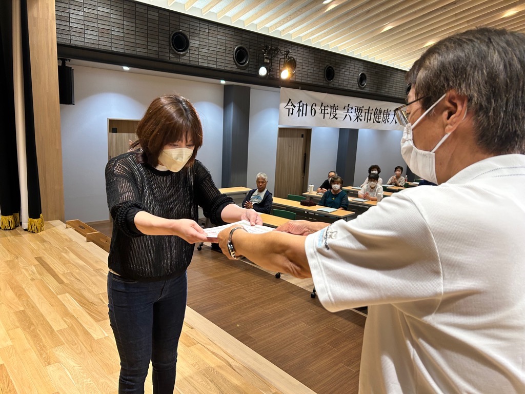 修了者代表の女性が修了証書を受け取っている写真