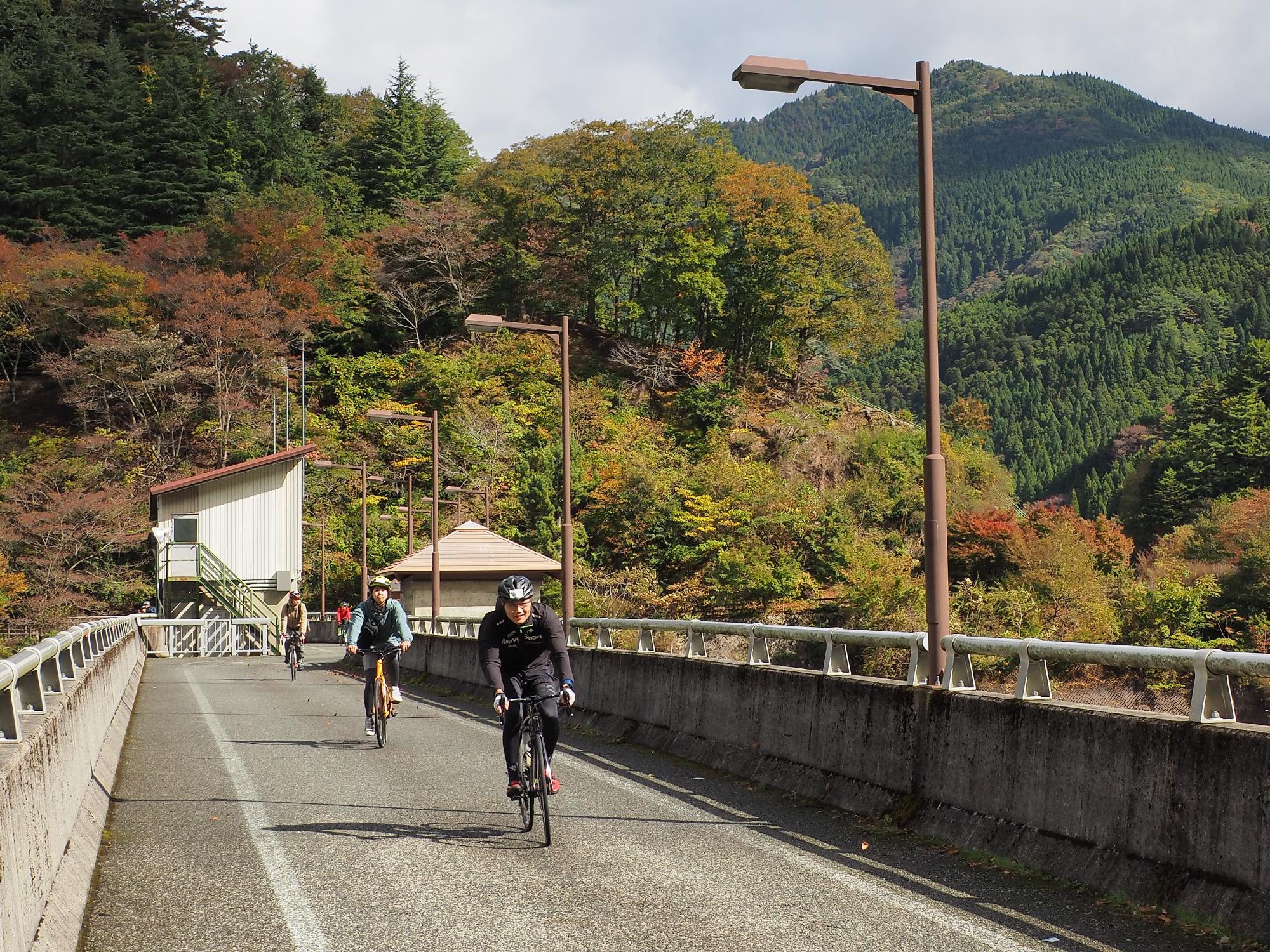 引原ダムの堰堤を参加者が自転車で通過している写真