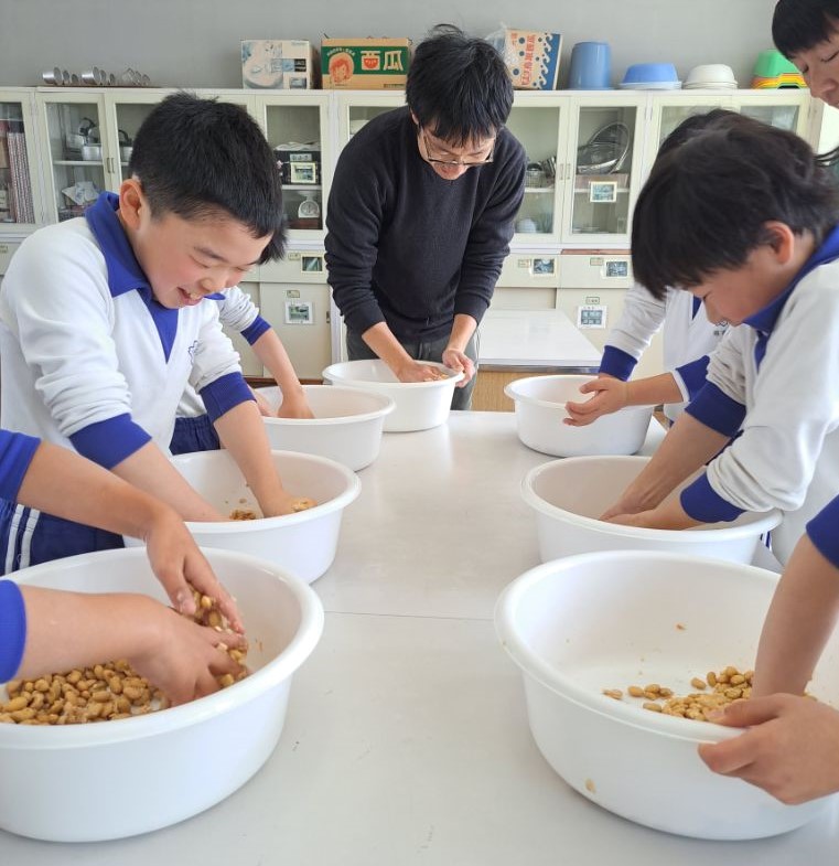 市内の小学生が味噌づくり体験を行っている様子の写真