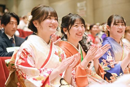 二十歳の祝典会場で女性が拍手している