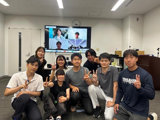 委員がピースしている