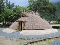 屋根が地面に置かれているような形の弥生時代の竪穴式住居の外観写真