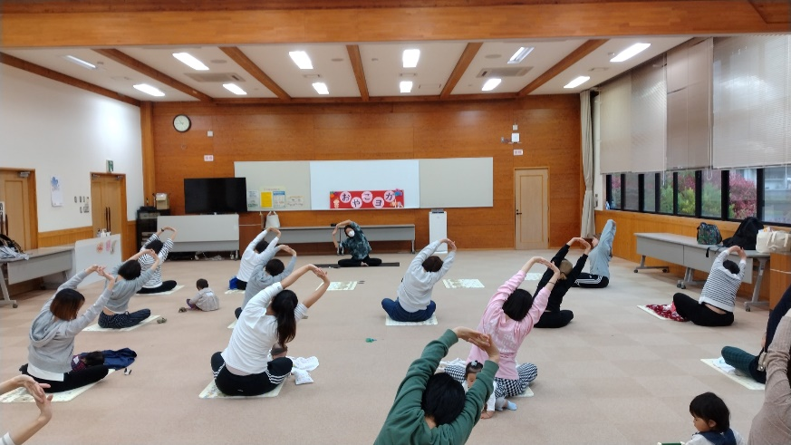 講師の動きにあわせて座って状態で背を伸ばす動きをする参加者の写真