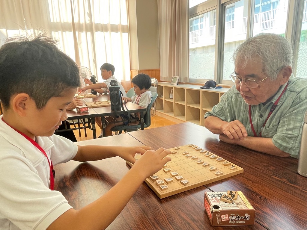 指導者が参加者に将棋の指しかたを指導している写真